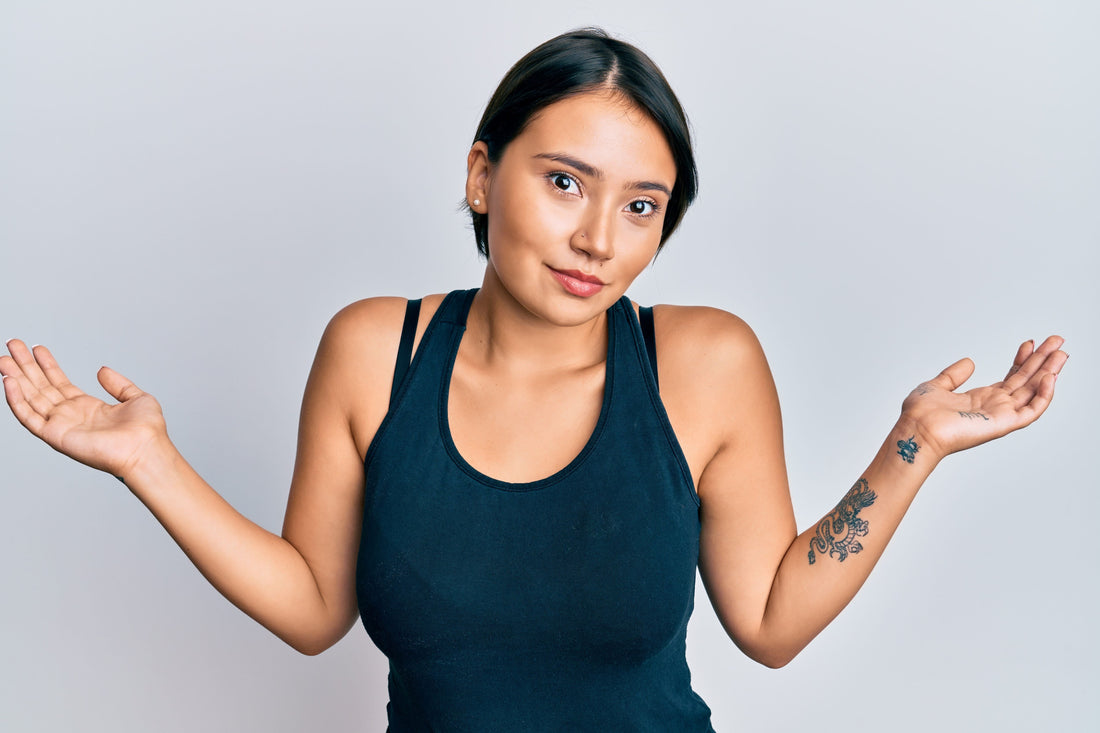 Beautiful women showing a confused jesture with her arms in black tank top