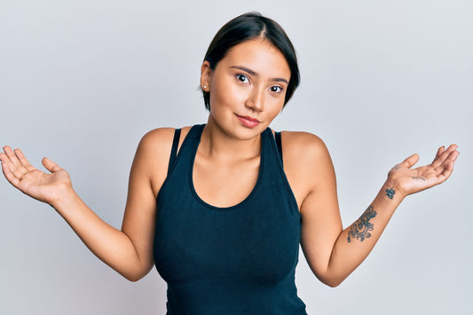 Beautiful women showing a confused jesture with her arms in black tank top