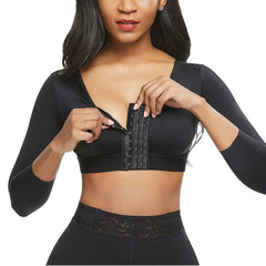 Woman wearing a black waist trainer against a white background