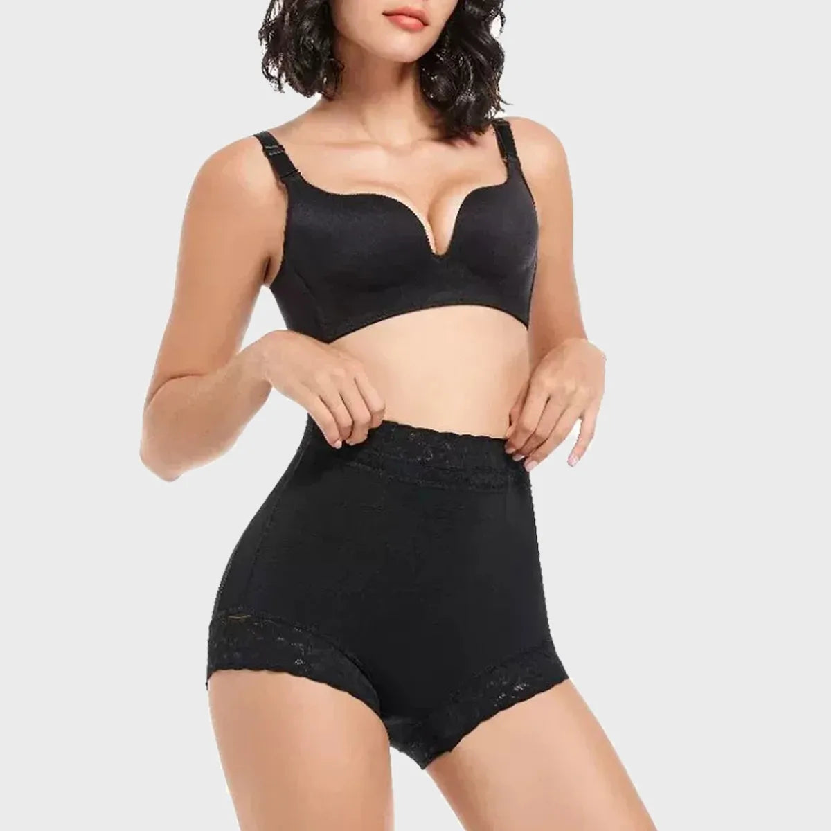 Woman wearing a black shapewear set on a white background